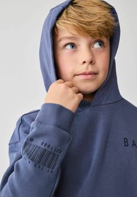 Námořnický modrý mikina s kapucí a přední kapsou. Obsahuje potisk čárového kódu na levém rukávu a minimalistické logo na hrudi. Materiál je z bavlněné směsi.
