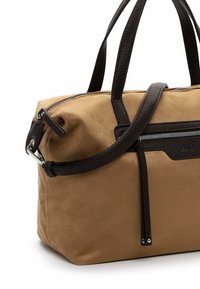 Tan suede handbag with dark brown leather accents, zip closure, dual top handles, and detachable shoulder strap. Textured materials enhance design.