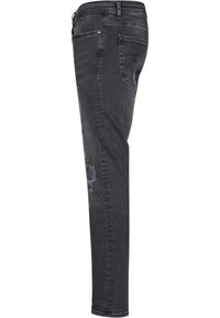 Jeans ajustados de mezclilla gris oscuro. Presentan un ligero desgastado en la rodilla, dos bolsillos traseros y cierre frontal con botón y pasadores para cinturón.