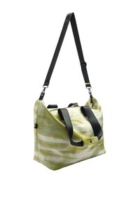 Zielono-biała torba materiałowa w wzory, z czarnym paskiem na ramię i uchwytami, z zamknięciem na zamek błyskawiczny i detalem na zatrzask.