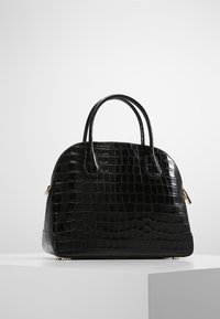 Czarna torebka z lakierowanej skóry z wypukłym wzorem krokodyla, w zaokrąglonym kształcie, z podwójnymi uchwytami i złotymi akcentami na suwaku.