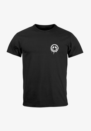 Schwarzes Baumwoll-T-Shirt mit kurzen Ärmeln, das auf der oberen linken Seite ein weißes Graffiti-artiges, kreisförmiges Smiley-Gesicht mit herzförmigen Augen zeigt.