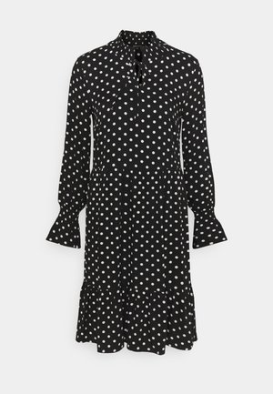 Schwarz-punkted Kleid mit langen Ärmeln, hohem Kragen, Knopfverschluss, ausgestellt Rüschen und geschichteter Rüschensaum. Hergestellt aus leichtem Stoff.