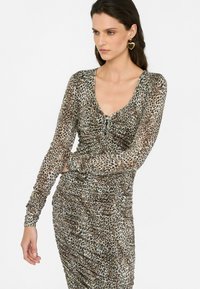 Rochie cu imprimeu de leopard, cu mâneci lungi, decolteu rotund și textură gathered. Confecționată dintr-un material ușor, cu o siluetă care se potrivește.