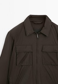 Dark brown zip-up jacket with wide collar and two large flap pockets on the chest, made of smooth fabric.