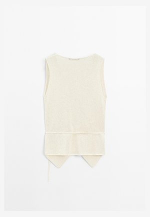 Sleeveless, cream-colored top with a textured knit finish. It features a tie waist and a rounded back hem with pointed edges.