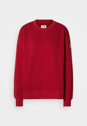 Sudadera roja de mezcla de algodón con mangas largas, cuello redondo, puños de canalé y un parche en la manga izquierda.
