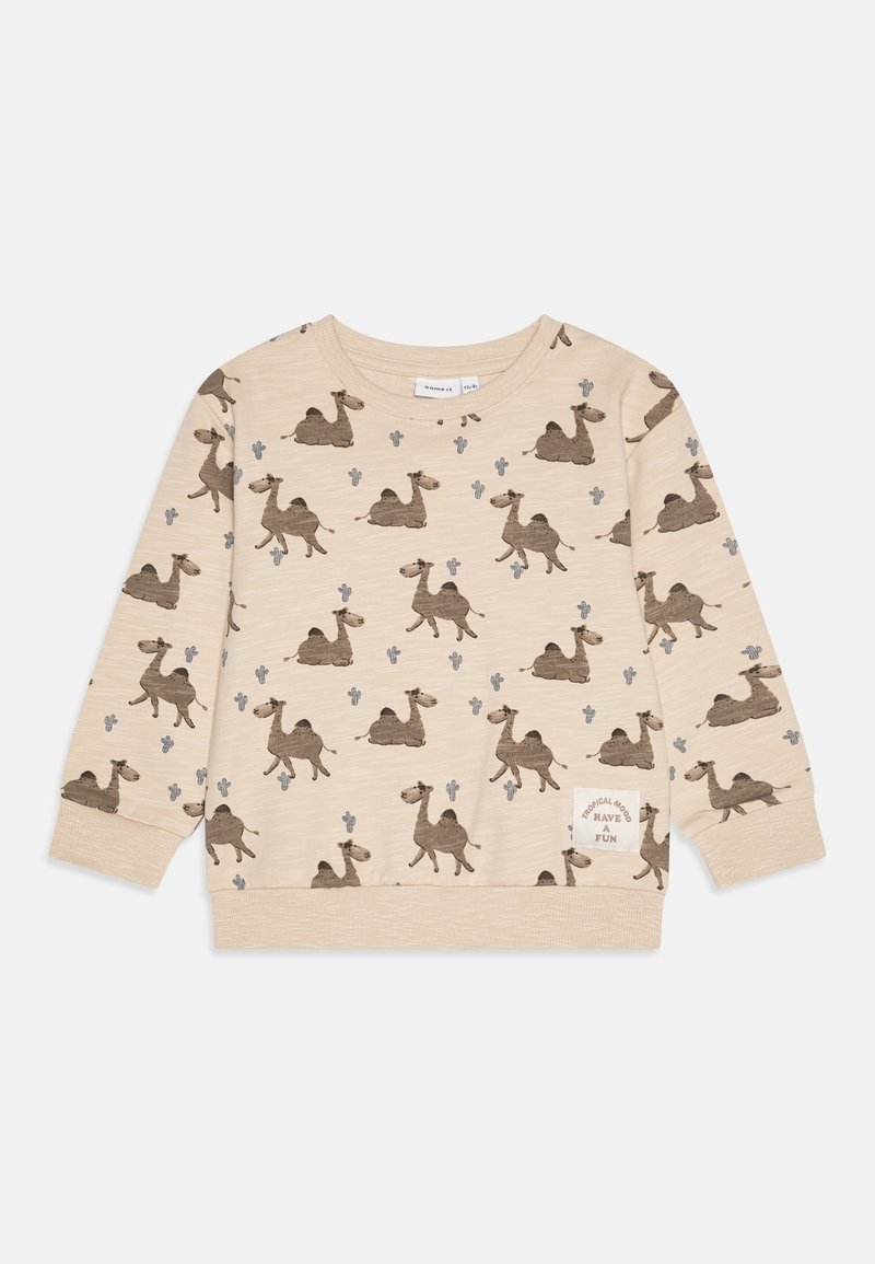 Beige színű pulóver, amelyen többszörös tevés minta és kaktuszok láthatók. Bordás mandzsetta és alsó szegély; bal alsó részen szöveges folt található.