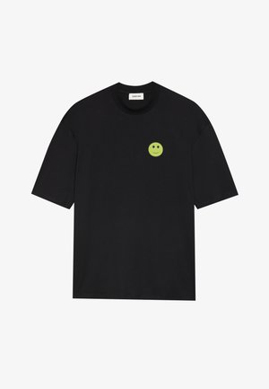 Svart bomull t-skjorte med korte ermer, med et lite grønt smilefjesgrafikk på venstre brystområde. Klassisk rund hals-design.