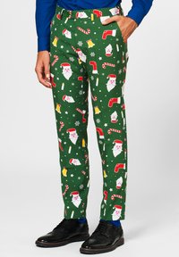 Pantaloni di tessuto verde con un motivo festivo che presenta facce di Babbo Natale, bastoncini di zucchero, campane e fiocchi di neve. Inclusi tasche laterali e passanti per cintura.