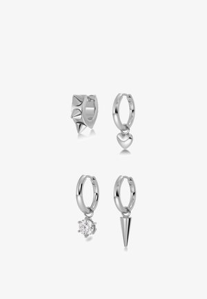 Quatre boucles d'oreilles anneaux en argent avec différents pendentifs : pointes, cœur, pierre précieuse transparente et cône en argent, présentées sur un fond blanc.