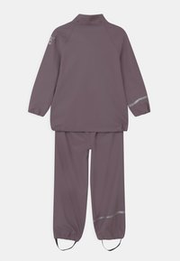 Paarse waterdichte regenjas en broek set, met elastische manchetten, een rechtopstaande kraag en reflecterende accenten op de mouwen en broek.