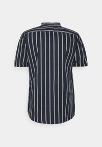 Camicia a maniche corte di colore blu navy con strisce verticali bianche, dotata di un colletto classico e di un orlo curvo. Realizzata in tessuto leggero.