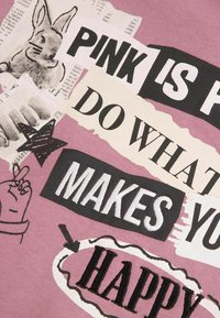 Bawełniana tkanina w stonowanym różu z kolażem czarnego, białego i kremowego tekstu. Zawiera ilustrację królika i grafikę gwiazd. Tekst zawiera motywacyjne frazy.