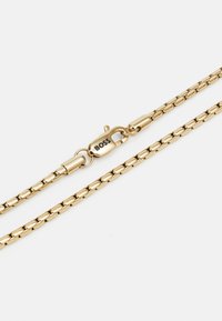 Collar de cadena tono dorado con eslabones rectangulares, cierre de langosta con la marca "BOSS", textura suave y acabado brillante.