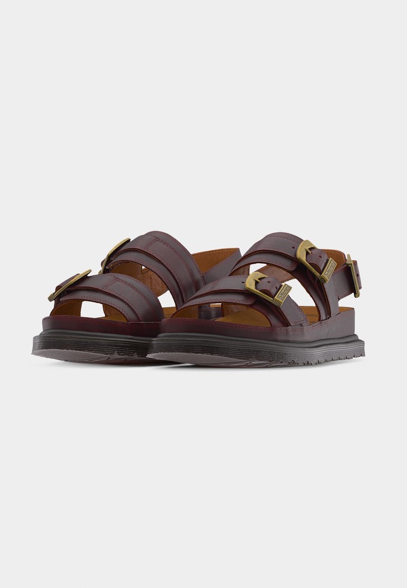 Braune Ledersandalen mit dicken schwarzen Sohlen, drei verstellbaren Messingschnallen und offenem Zehen- und Fersenbereich.