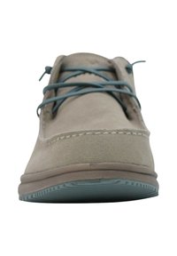 Scarpa in camoscio beige con lacci turchesi, punta arrotondata e dettagli di cuciture sottili. Texture morbida e suola in gomma con motivo a righe.