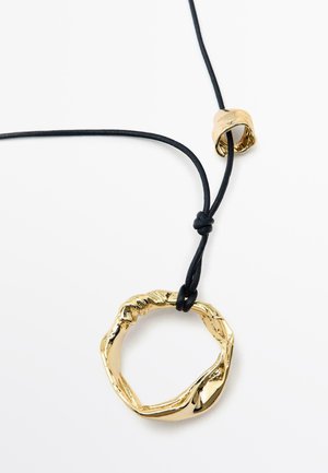 Pendentif texturé ton or en forme circulaire torsadée sur un cordon noir ajustable, maintenu par une perle d'accent lisse dorée.