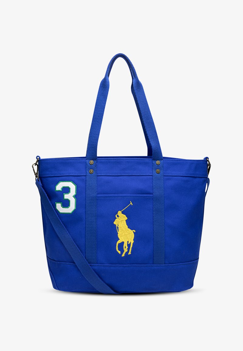 Τσάντα ώμου από μπλε καμβά με διπλές κοντές λαβές, ρυθμιζόμενο λουρί ώμου, κεντημένο κίτρινο λογότυπο παίκτη πόλο και πράσινη λεπτομέρεια με τον αριθμό 3.