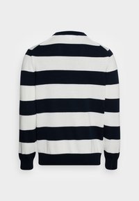 Stickad tröja med horisontella svart-vita ränder, rund halsringning och ribbade ärmslut. Mjuk textur, avslappnad passform.