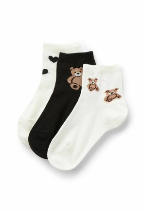 Kniehohe Baumwollsocken im Set in Schwarz und Weiß. Sie zeigen Bärenmotive in Braun auf der weißen Socke und Herzmuster auf der zweiten weißen Socke.