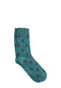 Tirkīza krāsas zeķes ar visu virsmu apdrukātu ar bišu rakstu melnā un dzeltenā krāsā. Izgatavotas no mīksta materiāla, tām ir ribota apmale un gluda tekstūra.