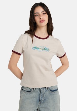 T-shirt beige clair avec un col et des poignets côtelés bordeaux. Présente un texte brodé en bleu et vert dans un design décoratif sur le devant.