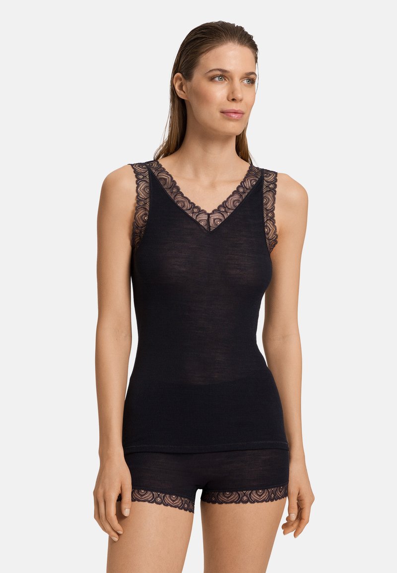Svart linne med spetsdetaljer och matchande shorts med spets. Mjuk, åtsittande design med V-ringning och delikat spets på axlarna och fållen.