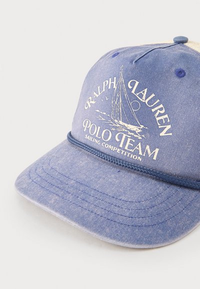 Μπλε καπέλο μπέιζμπολ με λευκό γραφικό ιστιοπλοϊκού σκάφους και κείμενο "Ralph Lauren Polo Team Sailing Competition" στην μπροστινή πλευρά.