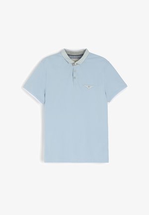 Jasnoniebieska koszulka polo z bawełny, z wzorzystym kołnierzykiem, zapinana na trzy guziki i z małą kieszonką z przodu.
