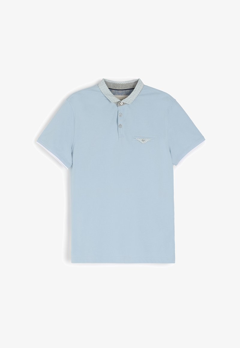 Jasnoniebieska koszulka polo z bawełny, z wzorzystym kołnierzykiem, zapinana na trzy guziki i z małą kieszonką z przodu.