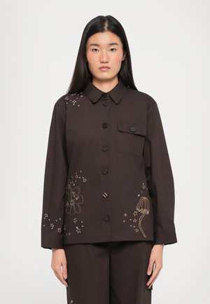 Chemise marron à manches longues avec broderies florales et d'étoiles, poche poitrine et col structuré. Fabriquée en tissu lisse.