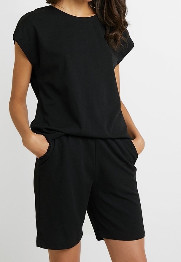 Black short-sleeve jumpsuit made of soft fabric, featuring a relaxed fit, side pockets, and a round neckline with a smooth texture.