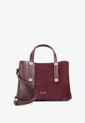 Burgunderfarbene Dune London Handtasche mit dualen Texturen, goldfarbenen Beschlägen, Obergriffen und abnehmbarem Schultergurt auf weißem Hintergrund.
