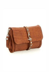 Borsa a tracolla in pelle marrone con pattina pieghevole, hardware argentato e tracolla decorativa con accenti argentati e borchie circolari. Design compatto.