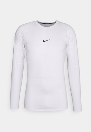 Hvit langermet treningsskjorte laget av glatt, stretchy stoff med en svart Nike-logo sentrert på brystet. Rund hals.