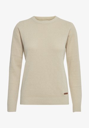 Kremo spalvos megztinis su struktūrizuota mezgimo raštu, apvalia iškirpte, ilgomis rankovėmis ir raukinėmis ant rankogalių. Priemonių štampelis yra mažas ženklas ant apatinio krašto.