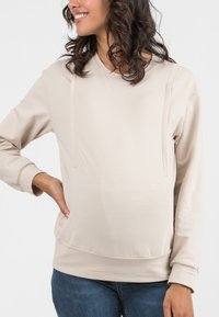 Felpa maternità beige con maniche lunghe, texture morbida, scollatura rotonda e dettagli sottili sul pannello anteriore. Adatta per un abbigliamento casual.