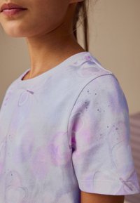 Tricou lavandă cu mâneci scurte, cu un model delicat de fluturi, material moale și variații subtile de culoare, cu guler rotund.