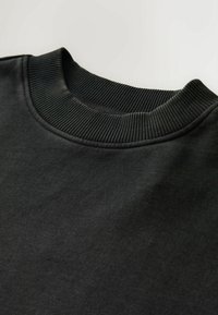 Hanorac negru cu guler rib Elastic. Materialul pare moale, având o suprafață ușor texturată. Fără modele sau embellismente vizibile.