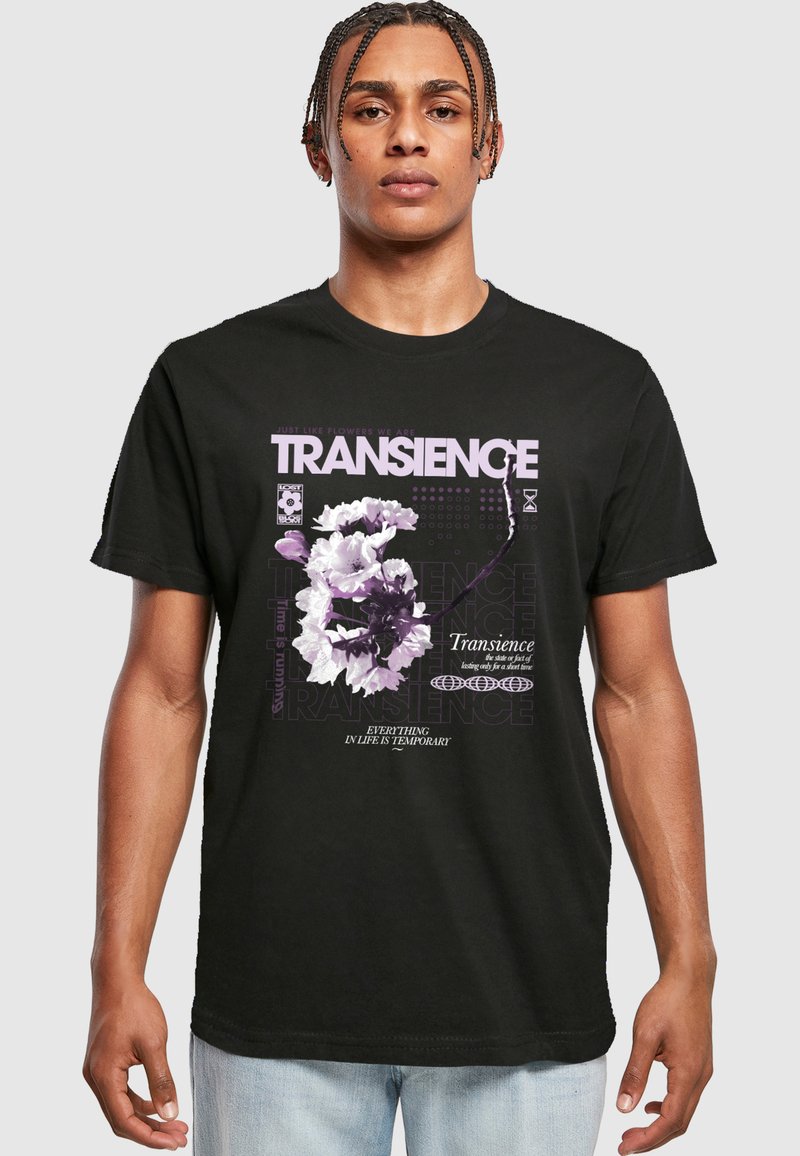 Melnās kokvilnas T-krekls ar ziedu grafiku un tekstu violetā krāsā, ar brīvu piegriezumu un īsām piedurknēm. Teksts ietver "TRANSIENCE" un "VISS DZĪVĒ IR PAGĀJĪGS."