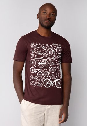 Dieprode t-shirt met een witte fietsafbeelding, voorzien van verschillende fiet ontwerpen in verschillende maten en posities, gemaakt van lichtgewicht stof.
