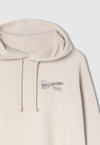 Beżowy polar z dużą przednią kieszenią, kapturem ze sznurkiem oraz wyszywanym napisem "Dziś niesamowite" z logo "BEAR MOTEL" poniżej.