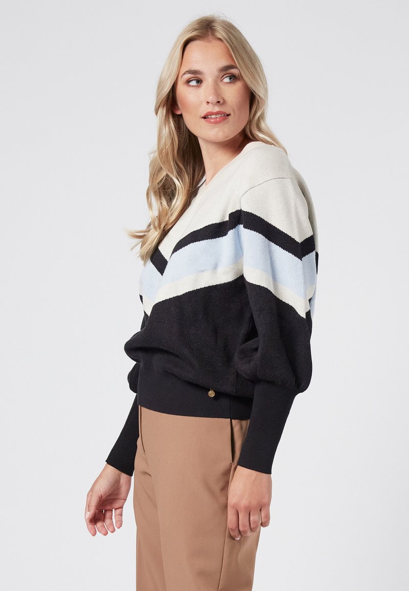 V-neck pullover sweater with black, cream, and light blue diagonal stripes; made of soft material; relaxed fit with ribbed cuffs and hem.