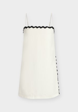 Λευκό φόρεμα-χιτώνας με λεπτές τιράντες και μαύρη κυματιστή διακόσμηση κατά μήκος της πάνω άκρης και μερικώς ορατή πλαϊνή ραφή.