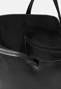 Czarna skórzana torba tote o gładkiej fakturze, z wewnętrzną kieszenią na zamek błyskawiczny i dwoma solidnymi uchwytami. Prosty, elegancki design bez widocznych wzorów.