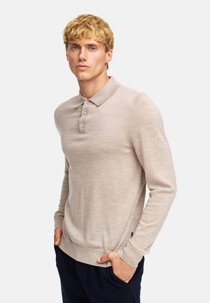 Beige polo shirt met lange mouwen, een kraag, een placket met drie knopen en geribbelde mouwen. Soepele textuur met subtiele stikdetails.