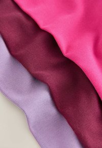 Fyra lager av tyg i olika nyanser: klar rosa, mörk burgunder, medel burgunder och ljus lavendel. Mjuk, slät textur med ett ribbat mönster.