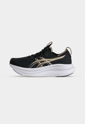 Zapatilla deportiva negra y beige con suela blanca gruesa y lengüetas de tirón en la lengüeta y el talón, vista de lado sobre fondo blanco.