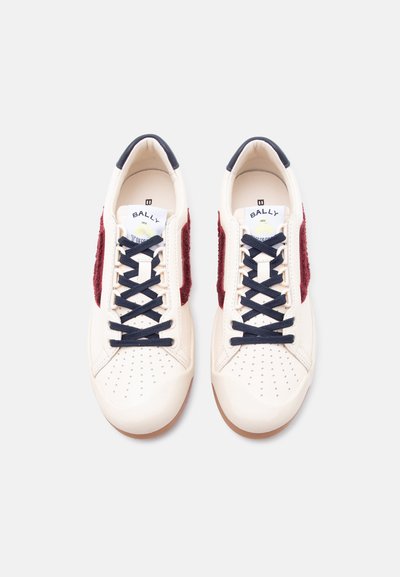 Baskets en cuir blanc avec des lacets bleu marine et des panneaux latéraux en daim bordeaux, vues de dessus sur un fond clair.